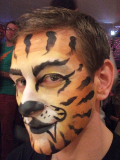 A photo of a man with his face painted like a tiger